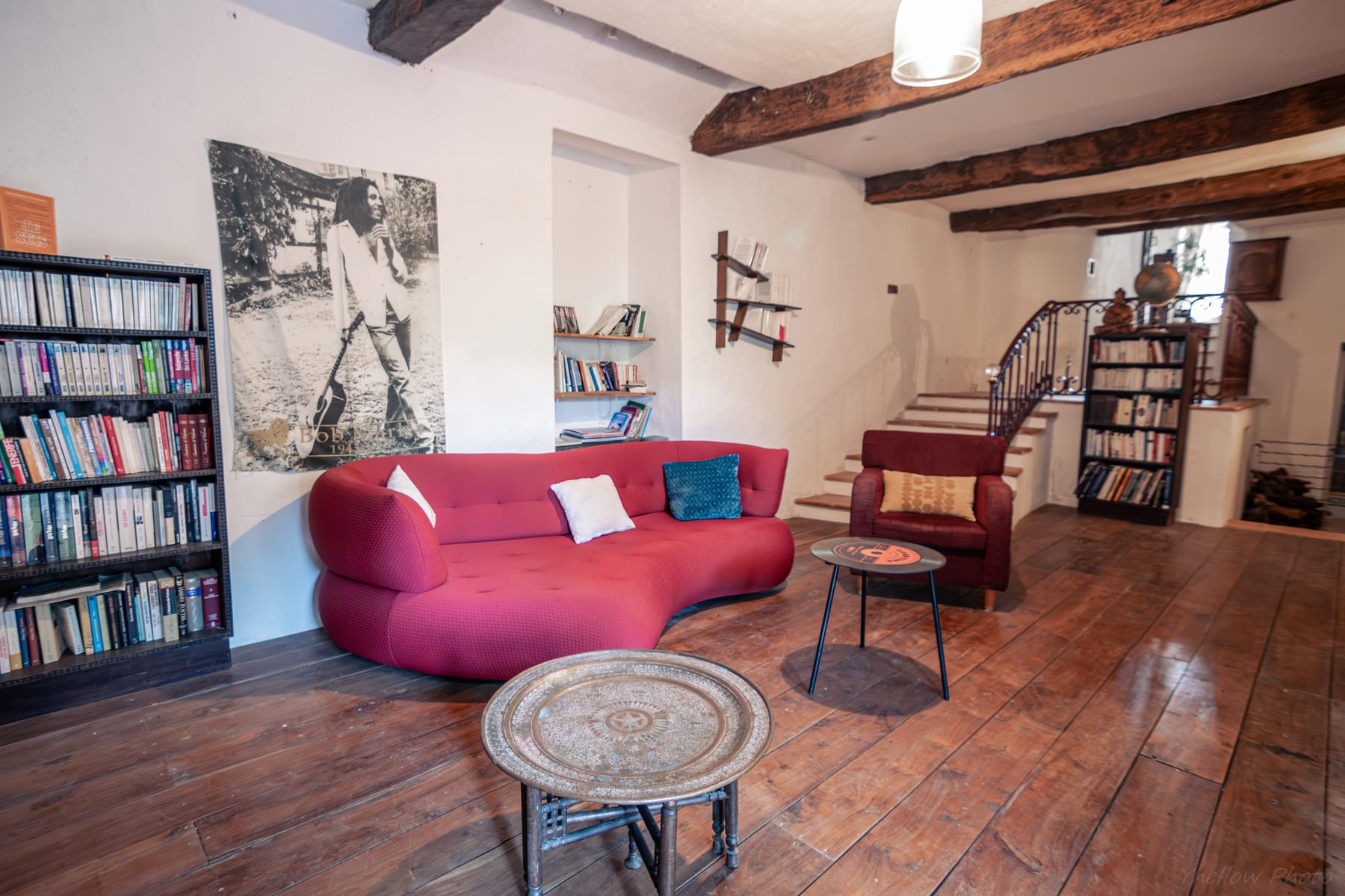 Salon bibliothèque avec cheminée, livres et espace lecture dans une maison d’hôtes de charme en Provence