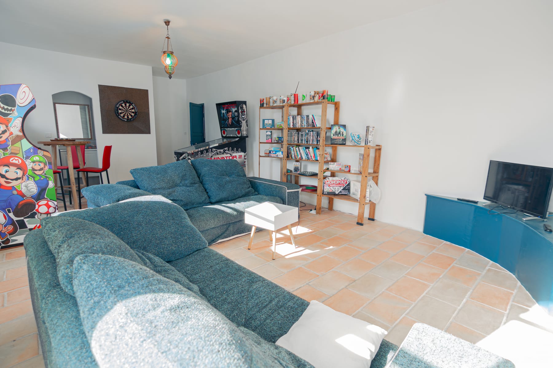 Grand salon avec télévision, bibliothèque et espace jeux dans une chambre d’hôtes du Var