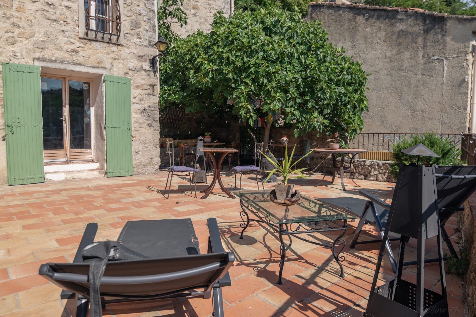 Terrasse ombragée avec salon de jardin au Couvent des Pallières