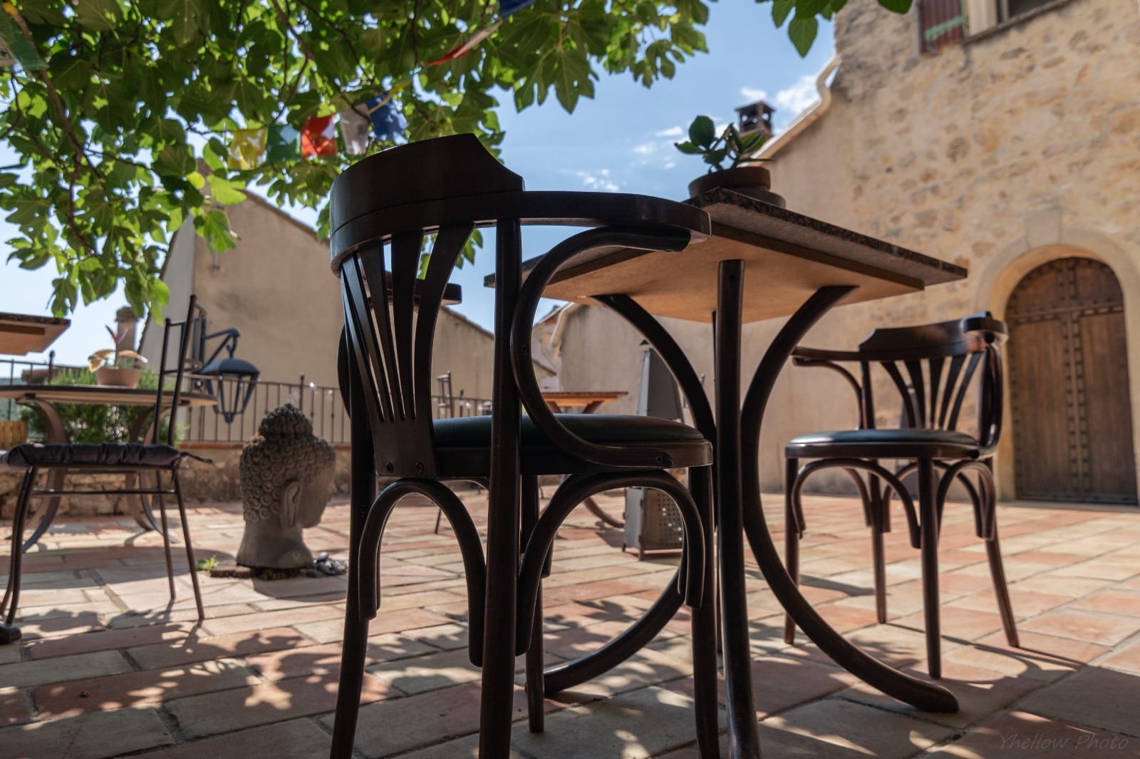 Terrasse en pierre avec tables bistrot au Couvent des Pallières
