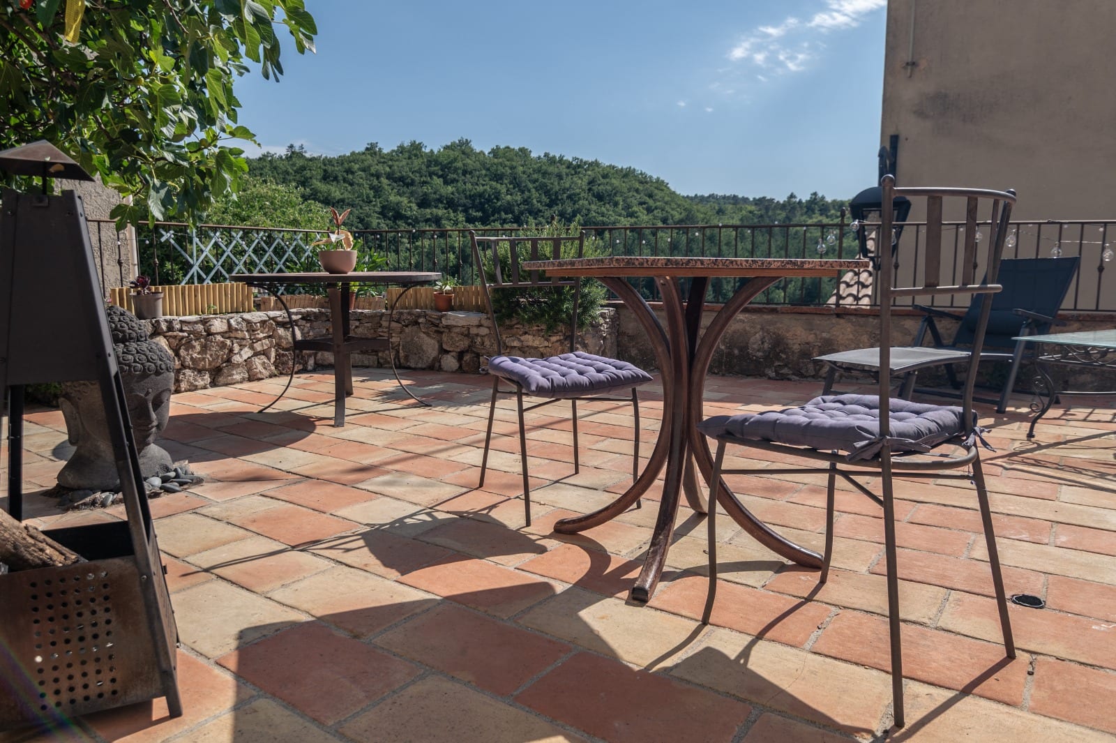 Terrasse avec tables et vue dégagée sur les collines provençales au Couvent des Pallières